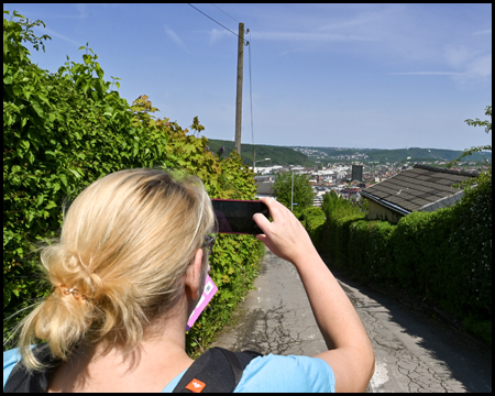 Eine Frau fotografiert in einer Kleingartenanlage eine weite aussicht auf Hagen