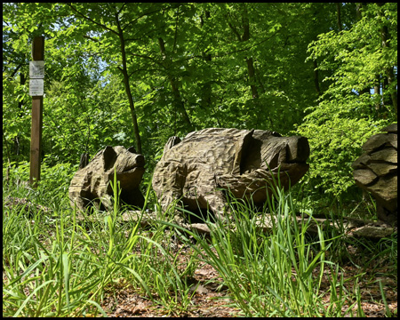 Schnitzkunst markiert in Form von Wildschweinen den Weg zum Saupark