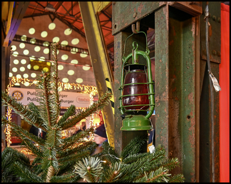 Eine Lampe hängt an einem Stahlträger, davor ein Weihnachtsbaum