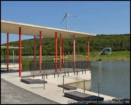 See mit Spielplatz und Halde Lohberg Nord im Hintergrund