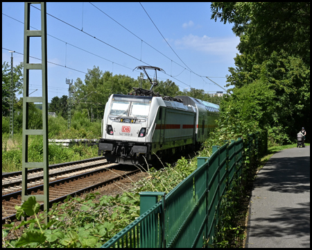 Ein Zug fährt an einem Radweg vorbei