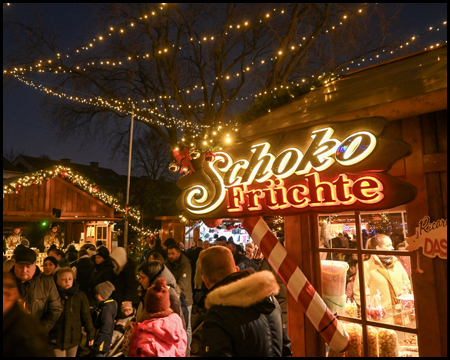 Weihnachtsmarkt-Stand mit Schokofrüchten im Dunkeln