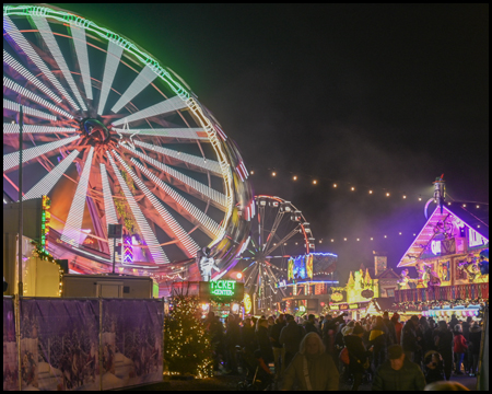 Drehende Fahrgeschäfte mit Beleuchtung im Dunkeln auf einer Kirmes