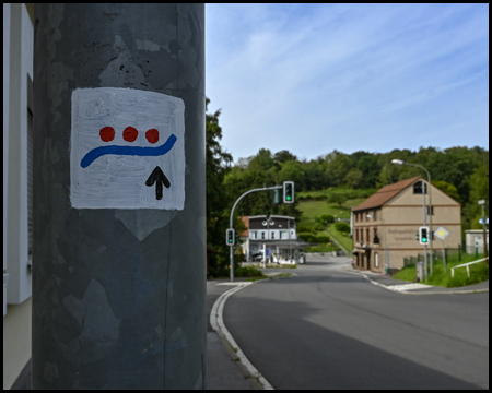 Wegmarkierung Deilbachsteig an einer Straßenlaterne in einem Ort