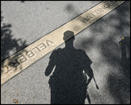 Markierung der Stadtgrenze am Boden mit Schatten des Fotografen