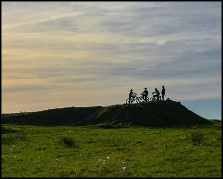 Radfahrende im Gegenlicht auf einer BMX-Strecke