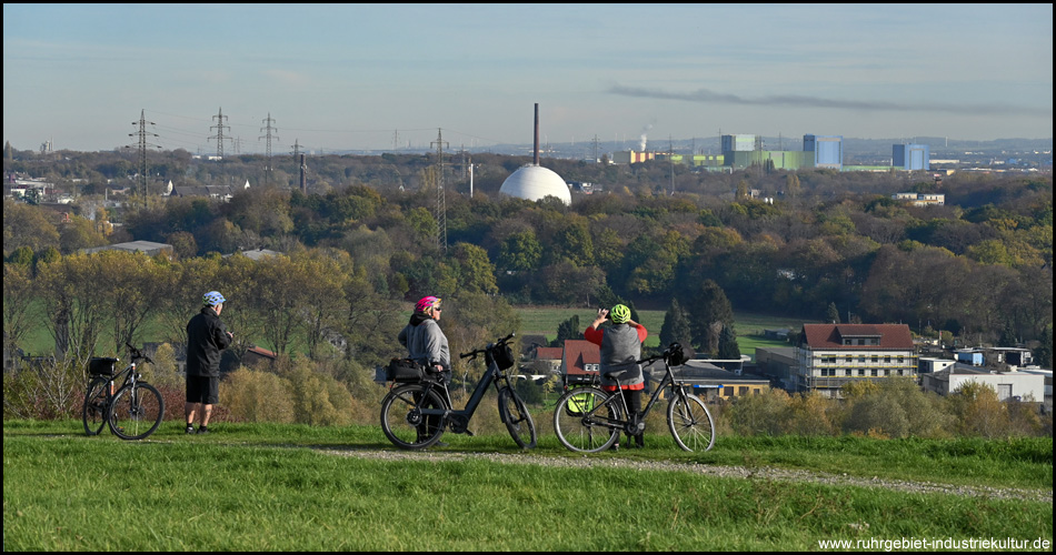 Radfahrende stehen auf einem Berg und schauen in die Ferne