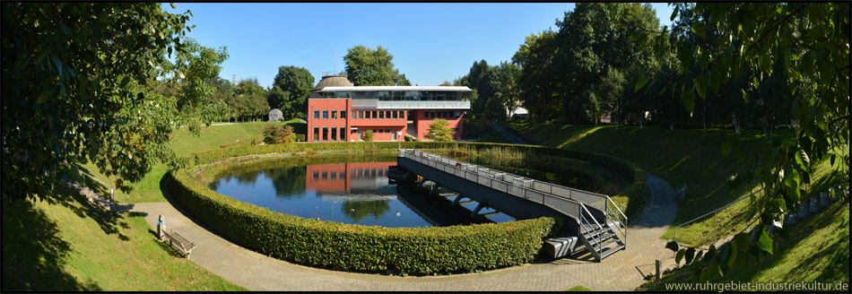 Panoramafoto vom Gelände des Emscher Klärparks: Wasserbecken, Betriebsgebäude und Faulturm