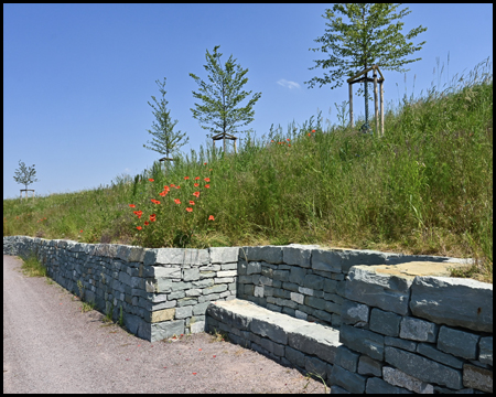 Hügel mit Steinmauer und Sitzbank