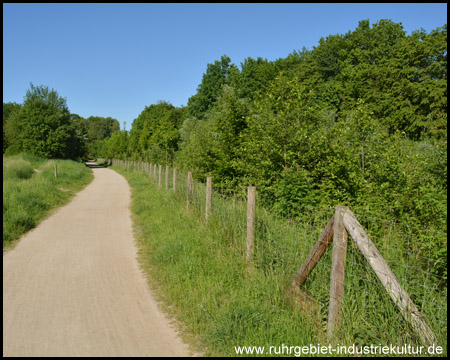 Idyllischer Weg durchs Grün – hinter dem Zaun plätschert´s