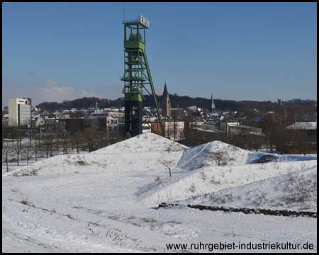 Blick von einem der grünen Hügel auf den Förderturm