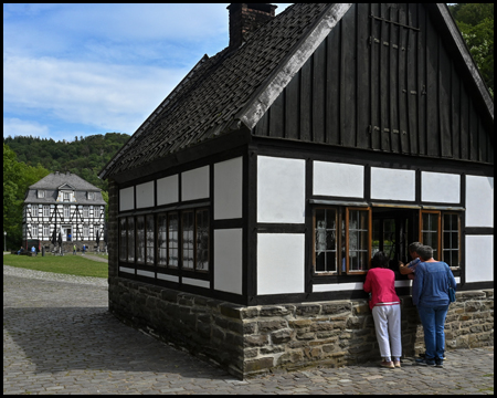 Bohrerschmiede. Menschen schauen durchs Fenster von draußen hinein