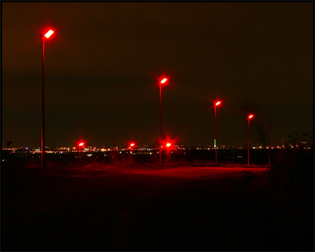 Beleuchteter Haldenhang mit Blick auf Duisburg