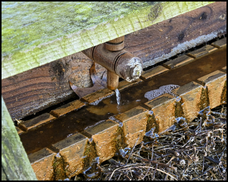 Hölzerner Wasserhahn und Riesel-Anlage