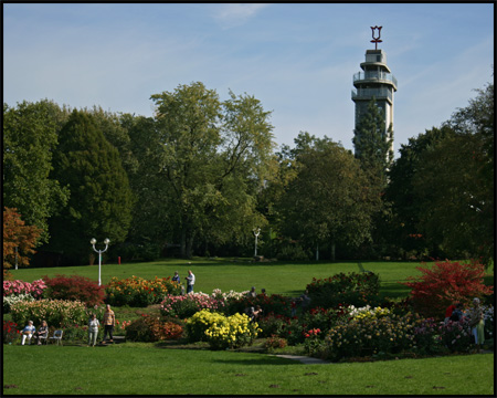 Blick über die Wiesen zum Grugaturm mit dem Logo des Parks