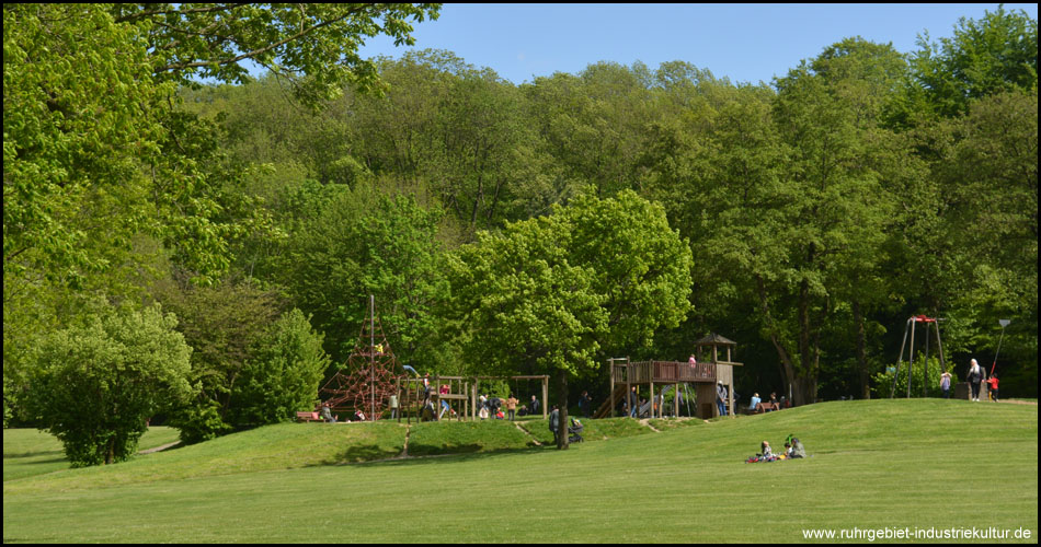 Einer der Kinderspielplätze im Park mit Kletterturm, Seilbahn, Schaukeln und Rutsche