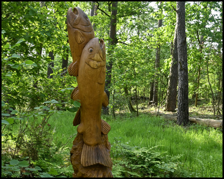 Holzskulptur Fische im Wald