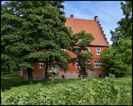 Rotes Haus hinter Bäumen