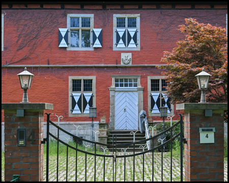 Eingang zu einem Backsteinhaus mit alten Fenstern mit Fensterläden