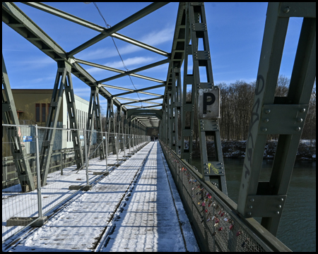 Alte Eisenbahnbrücke mit P-Schild im Schnee