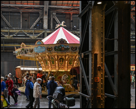 Ein Karussell hinter einer Stahlsäule der Jahrhunderthalle Bochum