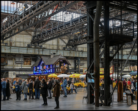 Eine Industriehalle mit Bierstand und Sitzgelegenheiten zum Essen