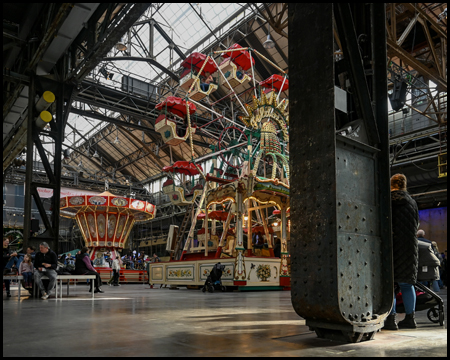 Riesenrad hinter einer Säule einer Stahlgerüst-Halle