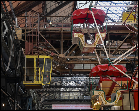 Riesenrad neben einer Kranbahn-Kabine in einer Halle