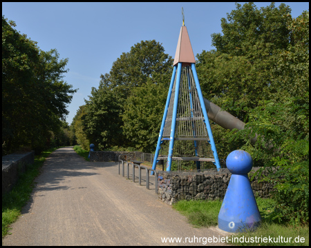 Eine Rutsche führt vom Turm und den Bahndamm hinunter