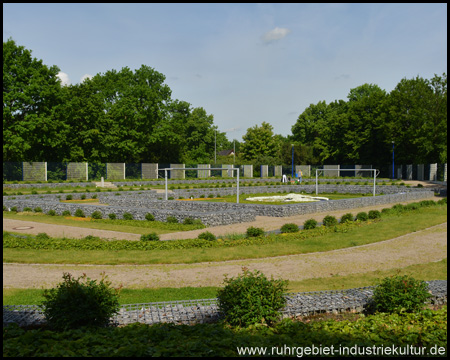 Schalke FanFeld auf dem Friedhof Beckhausen-Sutum mit Fußballtoren, blau-weißen Laternen und Zäunen und Tribüne