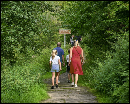 Wanderer im Wald mit Schild zur Ruine Isenburg