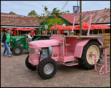 Ein rosafarbener Traktor als Sitzgelegenheit mit Bank und Tisch für Picknick.