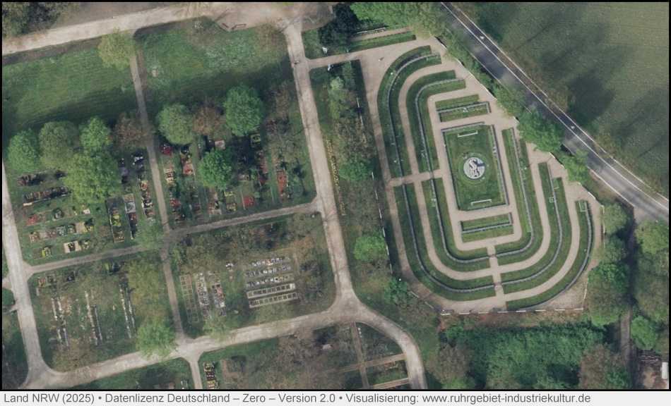 Luftbild eines Friedhofs. Besonders markant ist ein wie ein Stadion angelegter Teil mit ovalen Wegen und einem Fußballfeld in der Mitte.