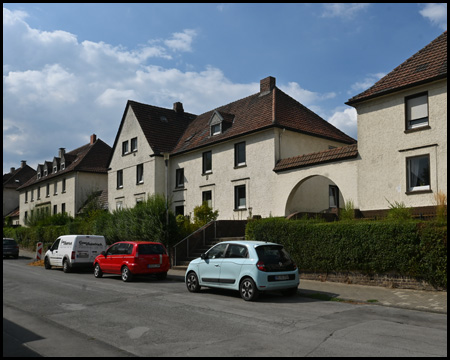 Haus an einer Straße mit parkenden Autos