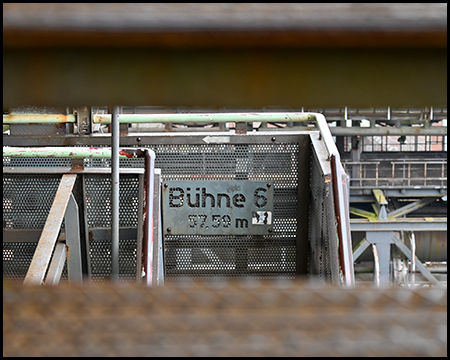 Blick durch Treppenstufen auf ein Schild mit der Aufschrift "Bühne 6"