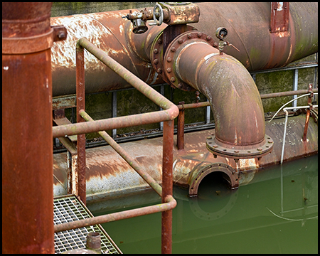 Rohre, die in einem von Wasser überfluteten Bassin enden