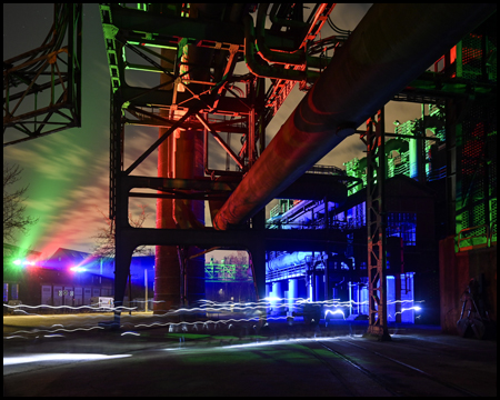 Industrieanlage in der Dunkelheit mit farbiger Beleuchtung als Licht-Installation