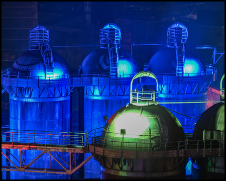 Blau und grün beleuchtete Silos als Teil des Hüttenwerks Meiderich in der Nacht