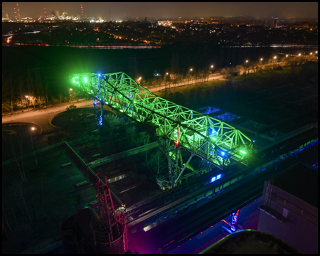 Aussicht vom Hochofen auf das grün beleuchtete Krokodil im Landschaftspark Duisburg-Nord