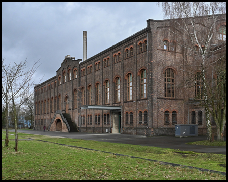 Backsteingebäude mit großen Fenstern und einem Portal mit Freitreppe