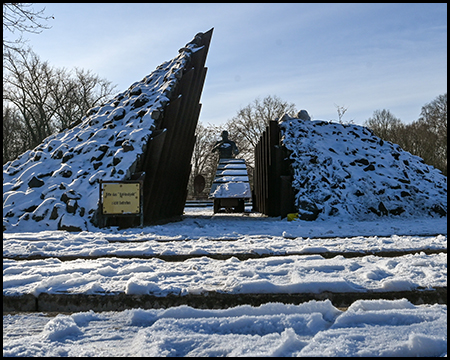 Skulptur eines Kohlehaufens mit einer Person auf einer Lore im Schnee