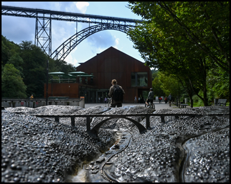 Miniaturmodell einer Brücke mit dem Original im Hintergrund