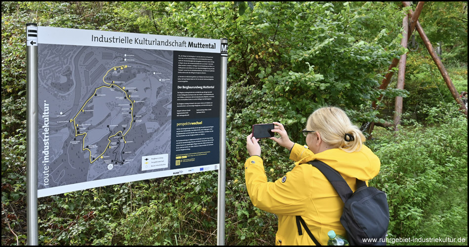 Eine Frau fotografiert eine Übersichtstafel zum Muttental