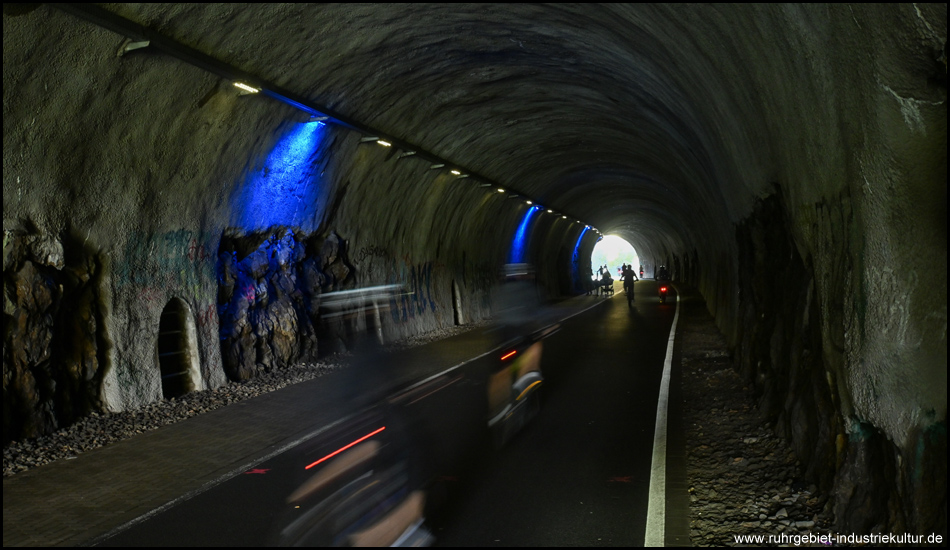 In einem blau beleuchteten Tunnel mit einem Radweg