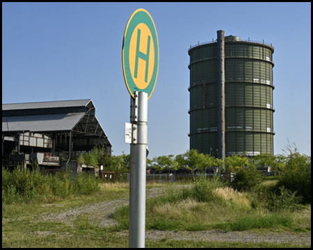 Gasometer und Bushaltestellenschild