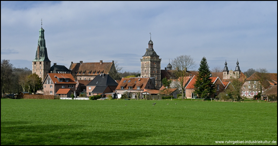 Eine Silhouette von Häusern und Türmen hinter einem Feld