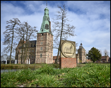 Steinlogo der Handwerkskammern aus der Froschperspektive gesehen. Dahinter Schloss Raesfeld