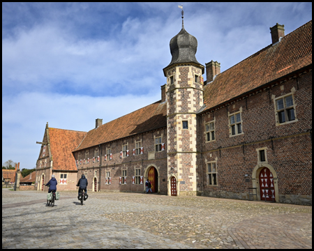 Schlossplatz und Vorburg mit markantem Turm. Davor einsame Radfahrer