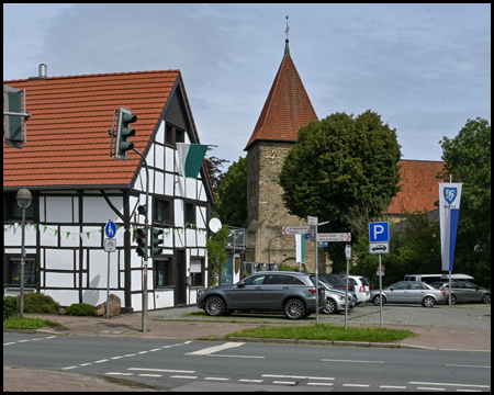 Fachwerkhaus und alte Kirche hinter einer Straße