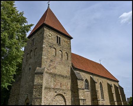 monumentale steinerne Kirche mit wuchtigem Turm und Strebpfeilern